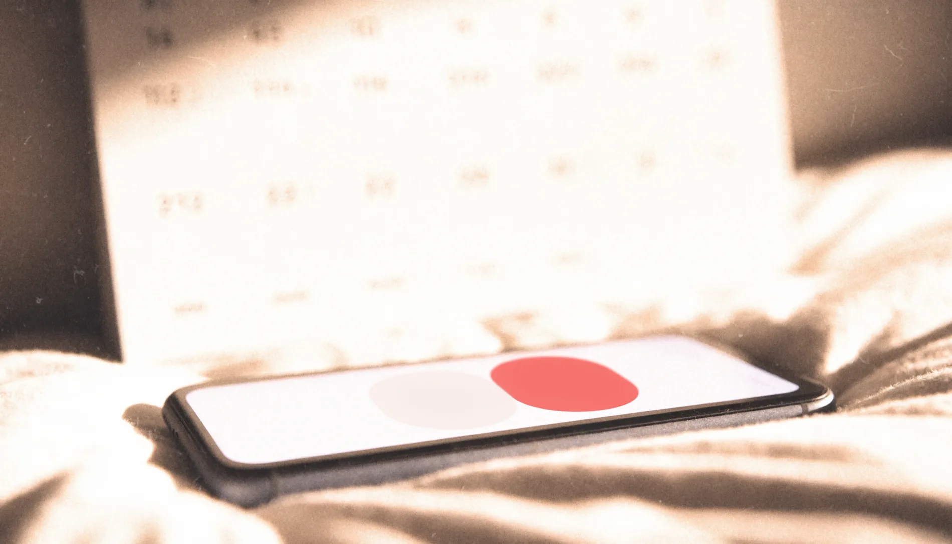 Phone resting on cream bedding