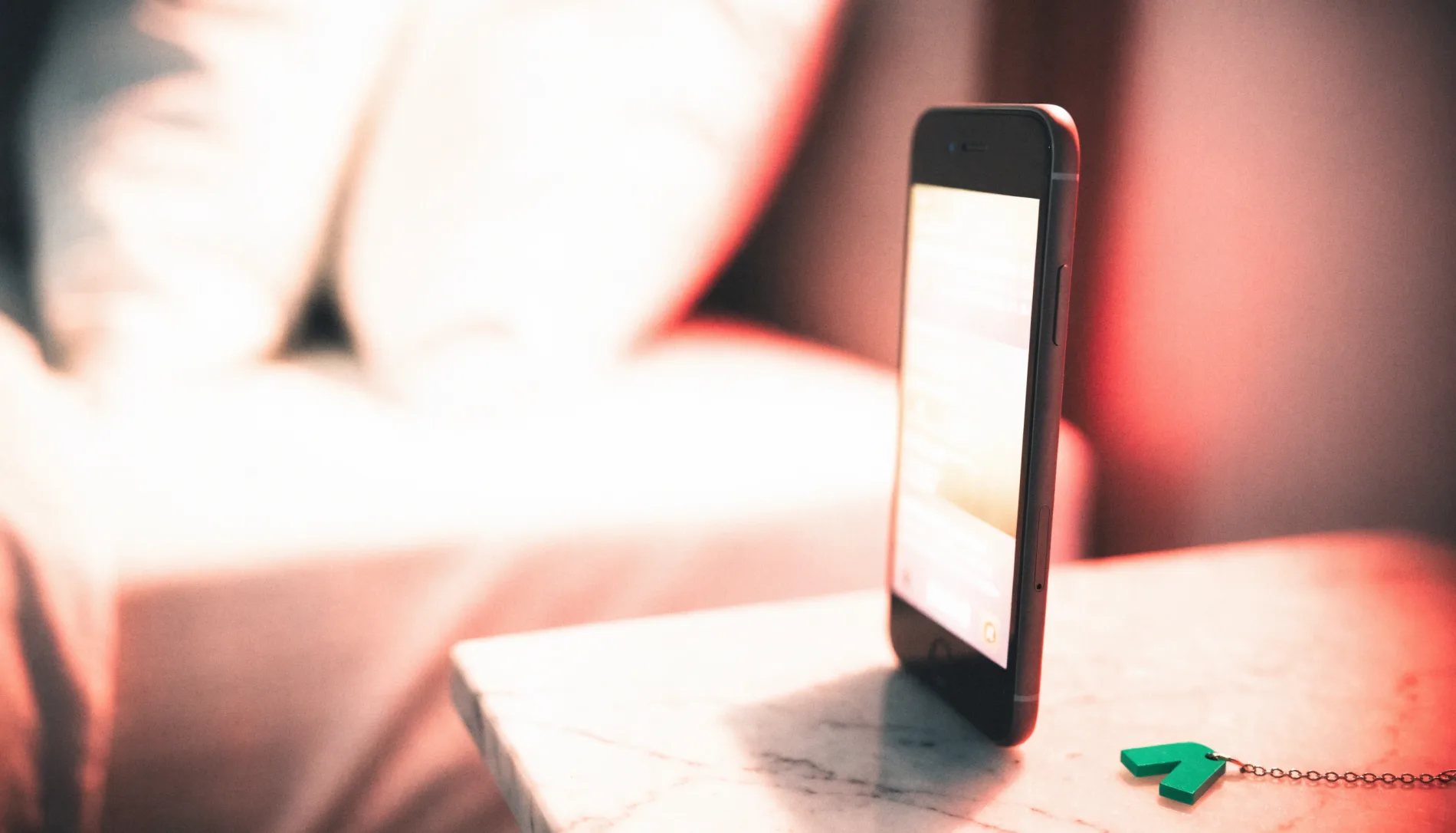 Phone on a bedside table in warm light